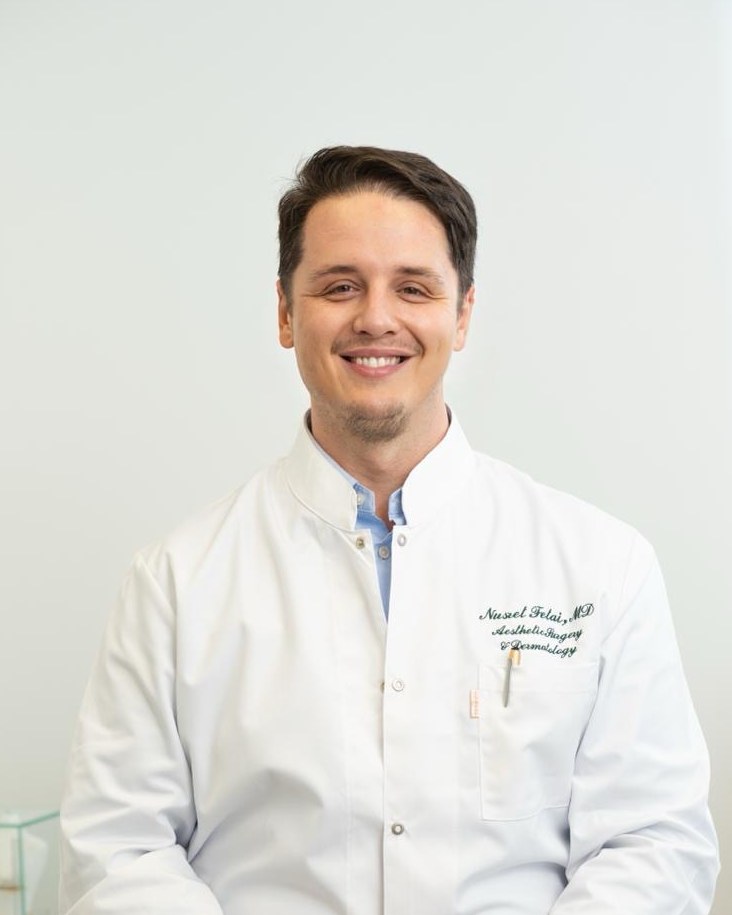 Dr. (univ. Te.) Nusret Fetai, Privatpraxis für Ästhetische Chirurgie und Haut in Düsseldorf, Porträt im weißen Arztkittel, Ansprechpartner für Fragen zur Ästhetischen Chirurgie
