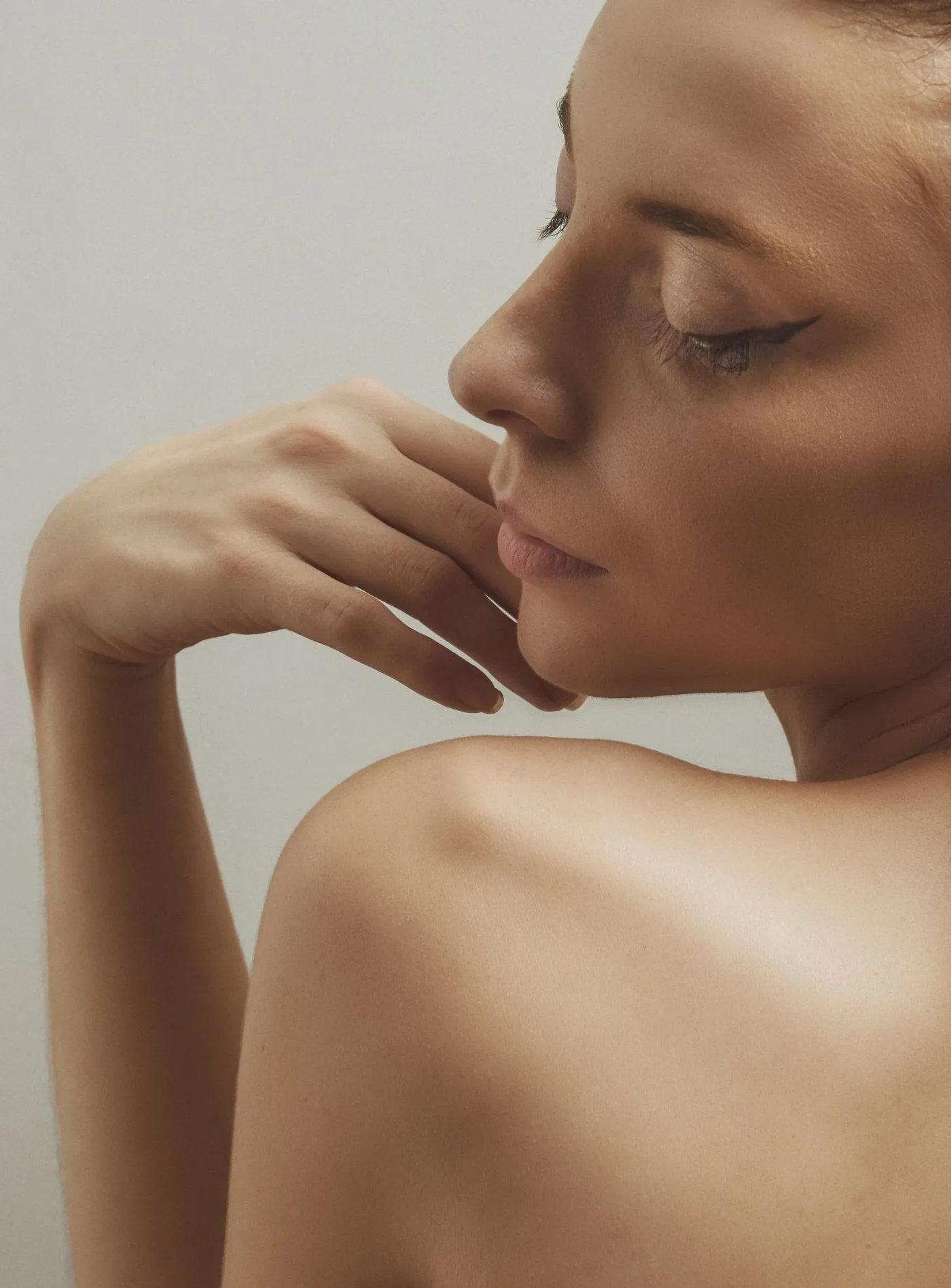 Profil einer Frau mit der Hand am Kinn, klare Hals und Kieferkontur, Modellaufnahme zur Radiesse Behandlung in Düsseldorf