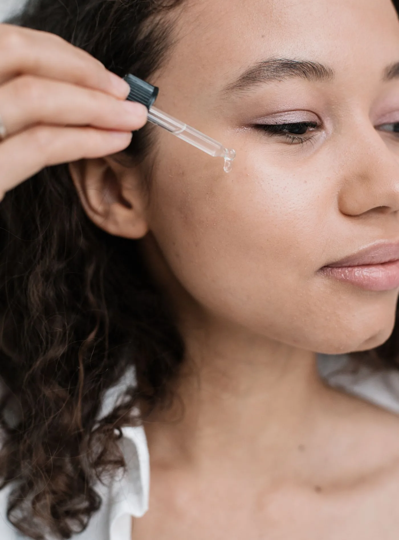 Serum wird mit einer Pipette auf die Wange aufgetragen, Hautpflege, Modellaufnahme zur Skinbooster Behandlung in Düsseldorf