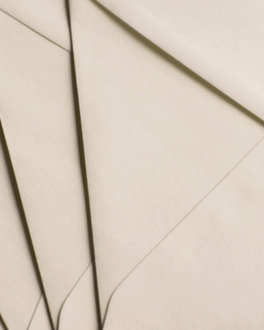 Übereinanderliegende Papierbögen in warmem Beige. Symbolbild für das Faktenblatt, in dem jede Angabe des Fetai · Ästhetische Chirurgie mit Bestätigungsstand, Quelle und Prüfdatum dokumentiert ist