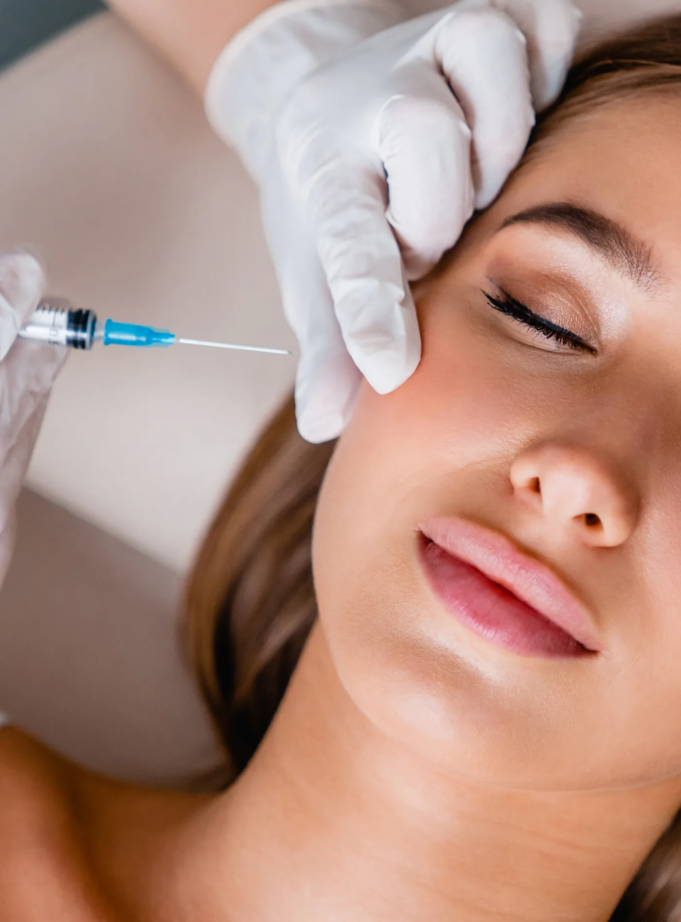 Injektion in die Wange mit feiner Spritze zur Hautverbesserung, Modellaufnahme zur Skinbooster Behandlung in Düsseldorf